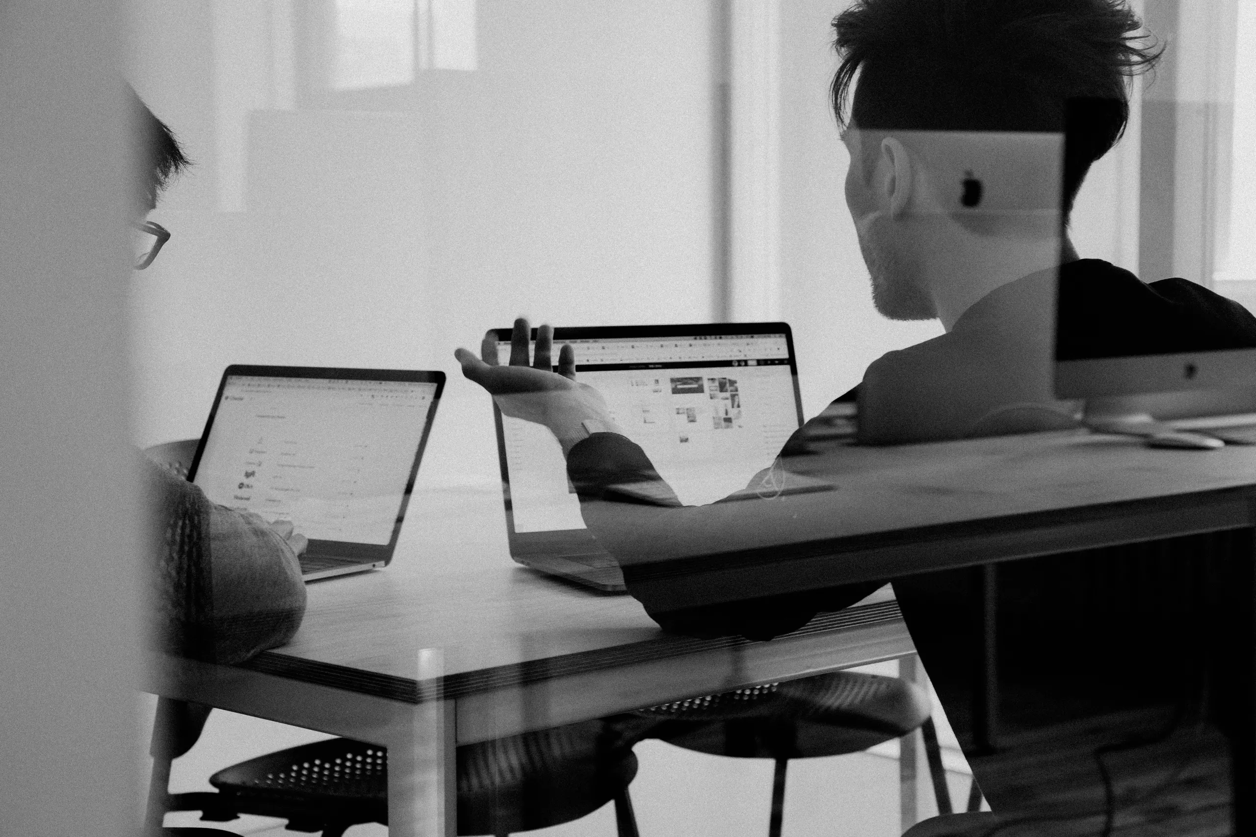 Consultants reviewing business processes together over a laptop