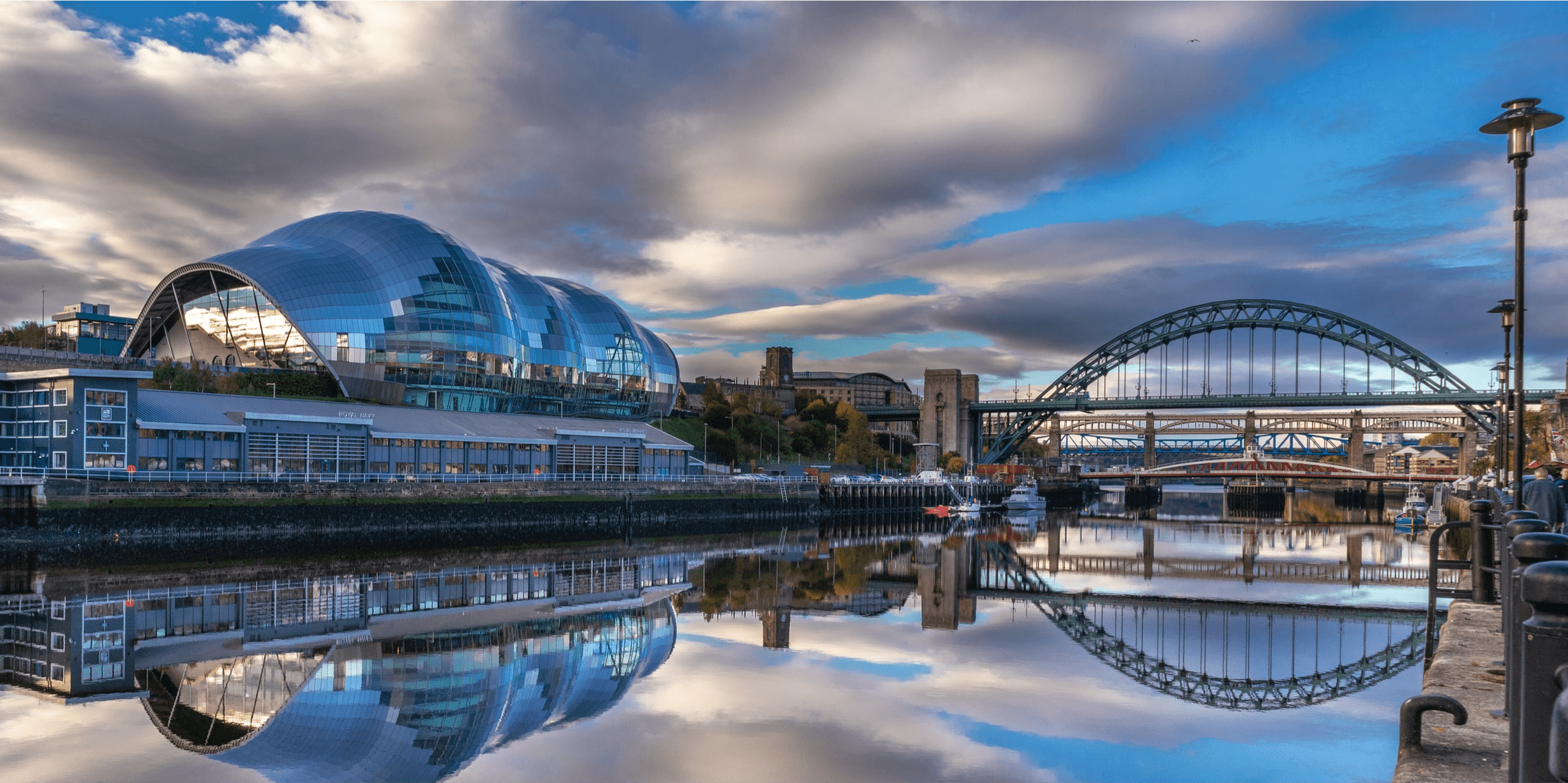 An image overlooking the sage and tyne bridge from across the water in Newcastle